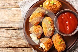 Italian Rice balls stuffed with mozzarella cheese and deep fried closeup on the plate. Horizontal top view photo