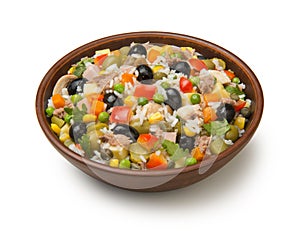 Italian rice salad with tuna in a brown ceramic salad bowl isolated on a white background.