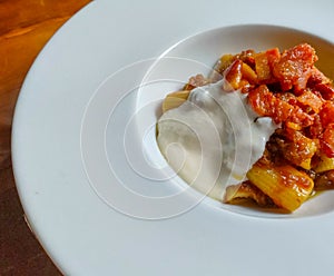 Italian rigatoni pasta with onions cream, guanciale and parmesan fondue