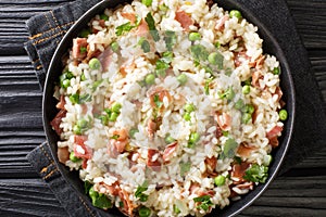 Italian risotto Risi e Bisi made from rice with peas and ham close-up in a plate. horizontal top view photo