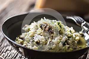 Italian risotto zucchini mushrooms and parmesan in dark plate