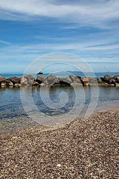 Italian rocky beach with small harbour and big villa. Holiday in Italy in summertime, seascape travel destination