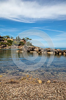 Italian rocky beach with small harbour and big villa. Holiday in Italy in summertime, seascape travel destination