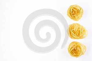 Italian rolled Raw noodles. Pasta isolated on white background . Egg homemade dry ribbon noodles, long rolled macaroni or uncooked