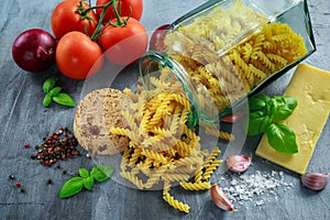 Italian Rotini pasta in vintage glass jar with vine ripe tomatoes, cheese, garlic, red onions and fresh basil leaves