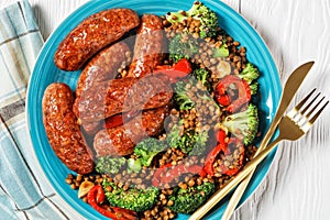 Italian sausages with lentils on a plate, top view
