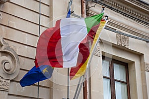 Italian, Sicilian and European flag together on facade of public building