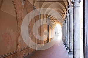 Italian sidewalk with ancient columns and old brick walls