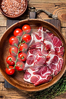 Italian sliced cured coppa ham with spices. wooden background. Top view