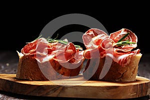 Italian sliced cured coppa with spices. Raw ham. Crudo or jamon with rosemary photo