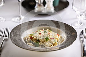 Italian Spaghetti Algio e Olio with Garlic Parmesan and chili peppers on restaurant festive table