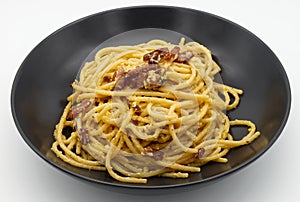 Italian Spaghetti alla Carbonara Pasta in a black dish isolated on white
