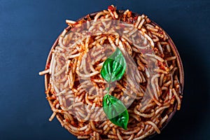 Italian spaghetti with a bolognese tomato meat sauce and basil in a plate.