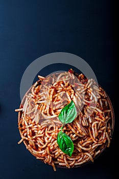 Italian spaghetti with a bolognese tomato meat sauce and basil in a plate.