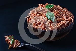 Italian spaghetti with a bolognese tomato meat sauce and basil in a plate.