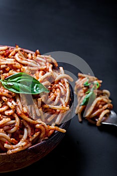 Italian spaghetti with a bolognese tomato meat sauce and basil in a plate.