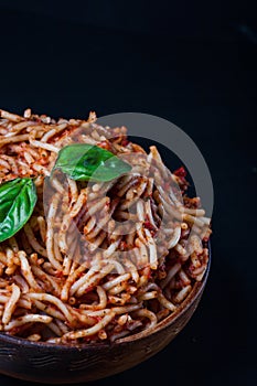 Italian spaghetti with a bolognese tomato meat sauce and basil in a plate.