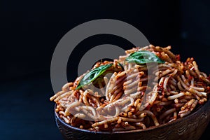 Italian spaghetti with a bolognese tomato meat sauce and basil in a plate.