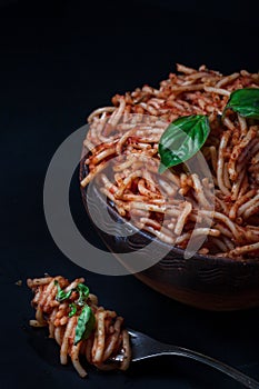 Italian spaghetti with a bolognese tomato meat sauce and basil in a plate.
