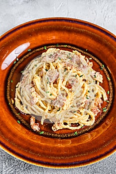 Italian Spaghetti Carbonara pasta with bacon, hard parmesan cheese and cream sauce. White background. top view