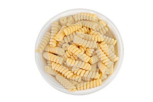 Italian spiral shaped pasta, Fusilli bucati macaroni in ceramic bowl, isolated on white background. Top view. Flat lay.