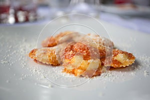 Italian starter of mozarella and tomato ravioli with parmesan sh