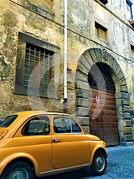Italian style, Fiat 500 Cinquecento, vintage door and arch, art and history in Viterbo city, Italy