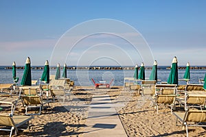 Italian summer on the Adriatic Sea: tyipical italian Riviera Romagnola beach clubs with sunbeds and beach umbrellas with typical