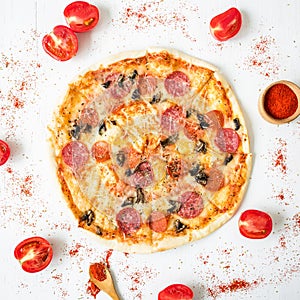 Italian tasty pizza with ingredients and spices on white rustic background. Flat lay, top view.