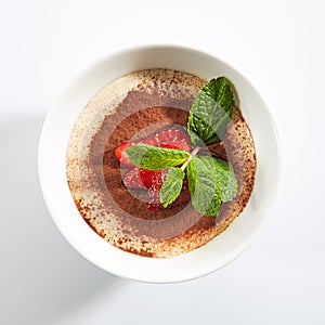 Italian Tiramisu Dessert with Green Fresh Mint and Sliced Strawberries