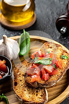 Italian tomato bruschetta with basil, garlic and olive oil on grilled or toasted crusty ciabatta bread, top view