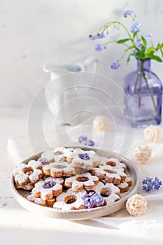 Italian traditional cookies are canestrelli on a white background with flowers. Homemade pastries. The concept of