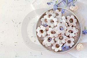 Italian traditional cookies are canestrelli on a white background with flowers. Homemade pastries. The concept of