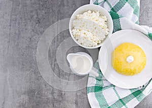 Italian traditional Polenta, porridge made from cornmeal. Mamaliga With Cottage Cheese and sour cream on rustic background.