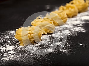 Italian traditional raw pasta on the black stone background