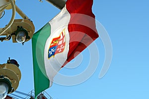 An Italian tricolour defaced with a variant of the arms of the Italian Navy and without a mural crow on the wind.