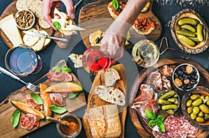 Italian wine snacks set, man's hand holding glass of rose