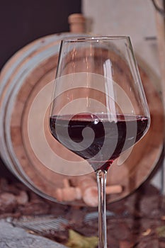 Italian wineglass red and wine cask on background in restaurant