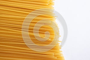 Italian yellow spaghetti isolated on white background, top view. Texture of pasta with selective focus viewed from above