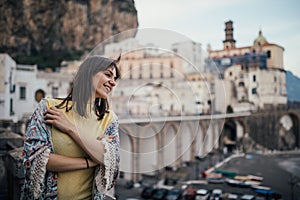 Italian young woman enjoying beautiful sunset in Amalfi on Amalfi coast in southern Italy.Italian experience, day trip to seaside