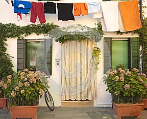 Italy, Burano: house with flowers and laundry hanging
