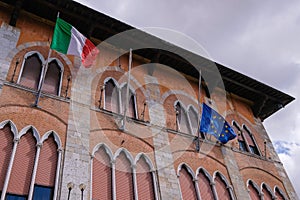 Italy and European Union flags waving, Europe`s flag is lowered to half-mast as a sign, Pisa, Tuscany, Italy, Europe