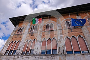 Italy and European Union flags waving, Europe`s flag is lowered to half-mast as a sign, Pisa, Tuscany, Italy, Europe