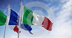 Italy and the European Union flags waving in the wind on a sunny day