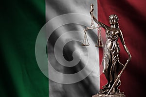Italy flag with statue of lady justice and judicial scales in dark room. Concept of judgement and punishment