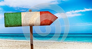 Italy flag on wooden table sign on beach background. It is summer sign of Italy