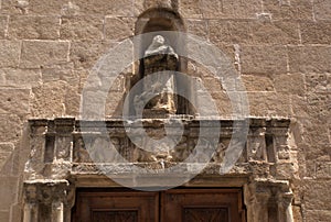 Italy, the island of Sardinia. The city of Alghero. An ancient church in the old medieval city. A carved surround to a door.