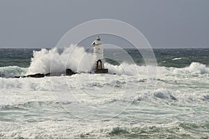 Italy, `Mangiabarche`, Storm. Waves smash against lighthouse or beacon.