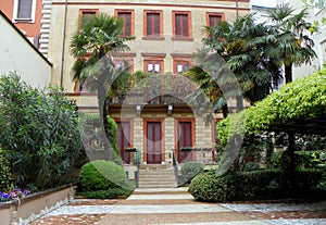 Italy, Milan, villa with palm trees and bushes