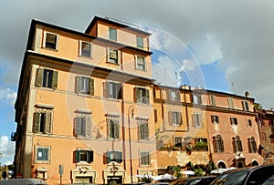 Italy, Rome, 2 Piazza di Santa Maria in Trastevere, ancient yellow mansion with shutters